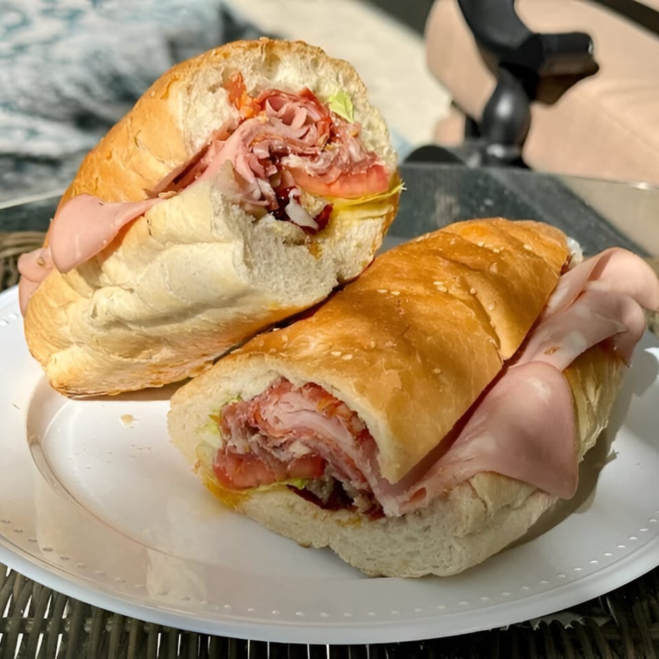 Two halves of a WhatSub Italian sub sandwich, filled with meats, cheese, lettuce, and tomato.