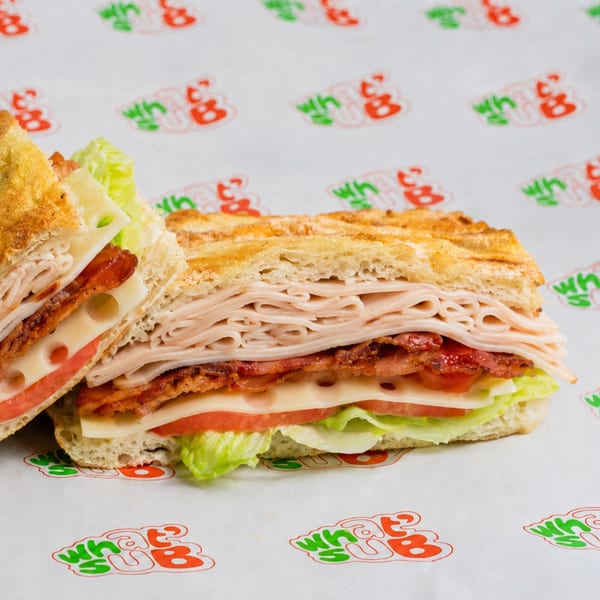 A turkey, bacon, Swiss cheese, tomato, and lettuce sandwich on toasted bread.
